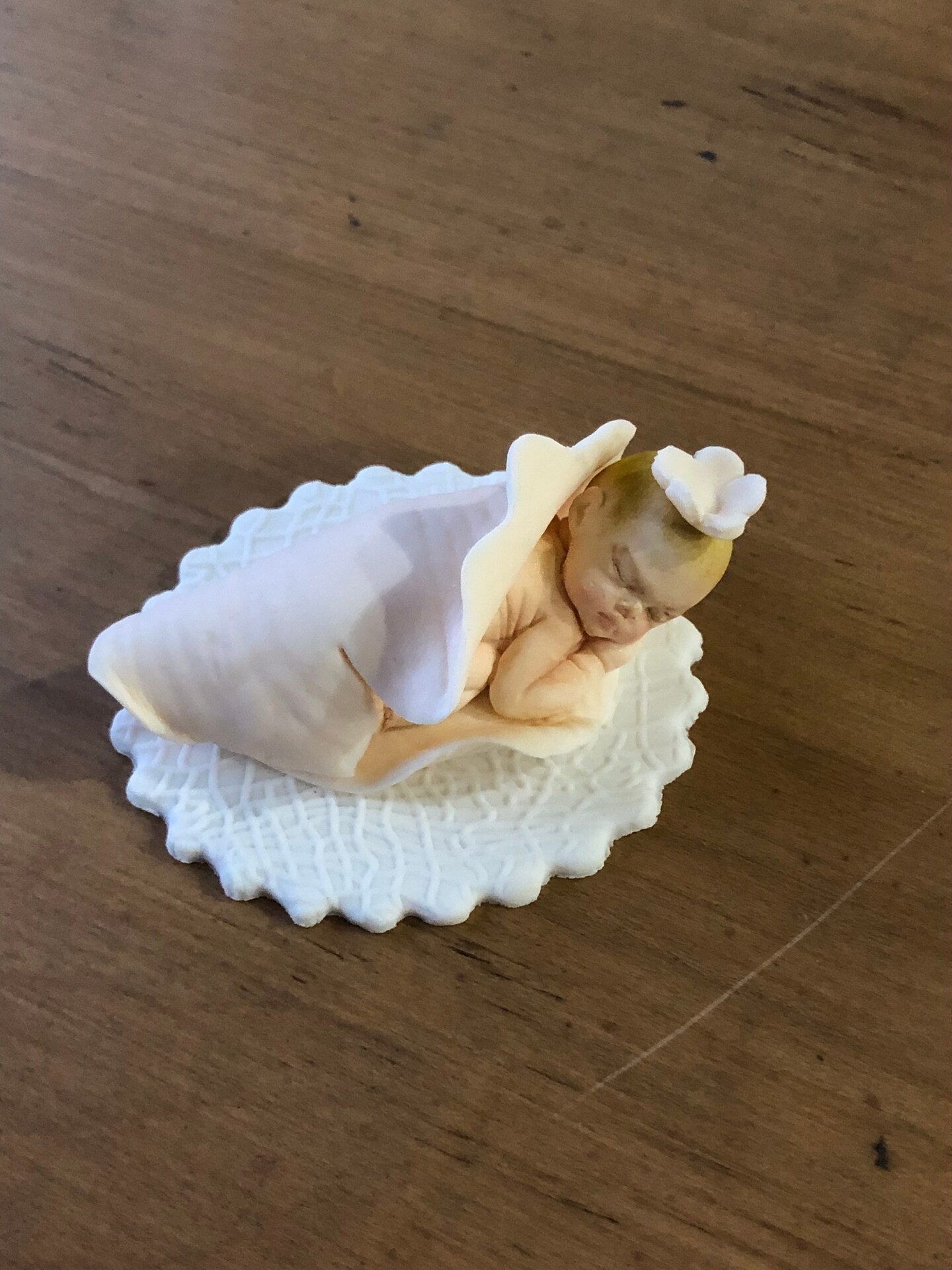 New born sleeping baby girl in peach petal. Fondant Baby cake topper
