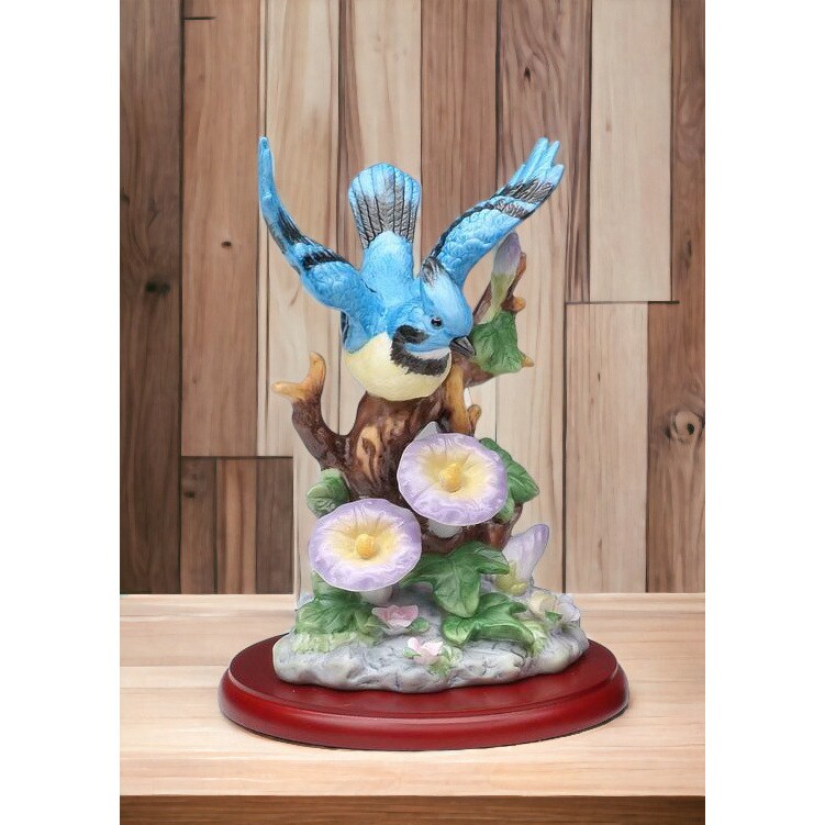 The ceramic bird statue on the tree is blue buy