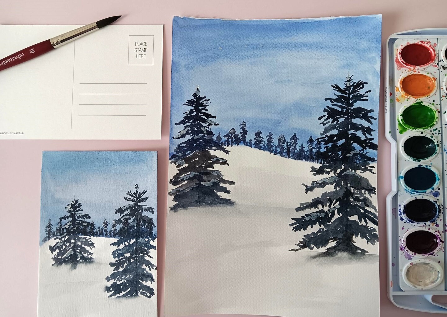 watercolor painting kit of a snowy hill with evergreen trees