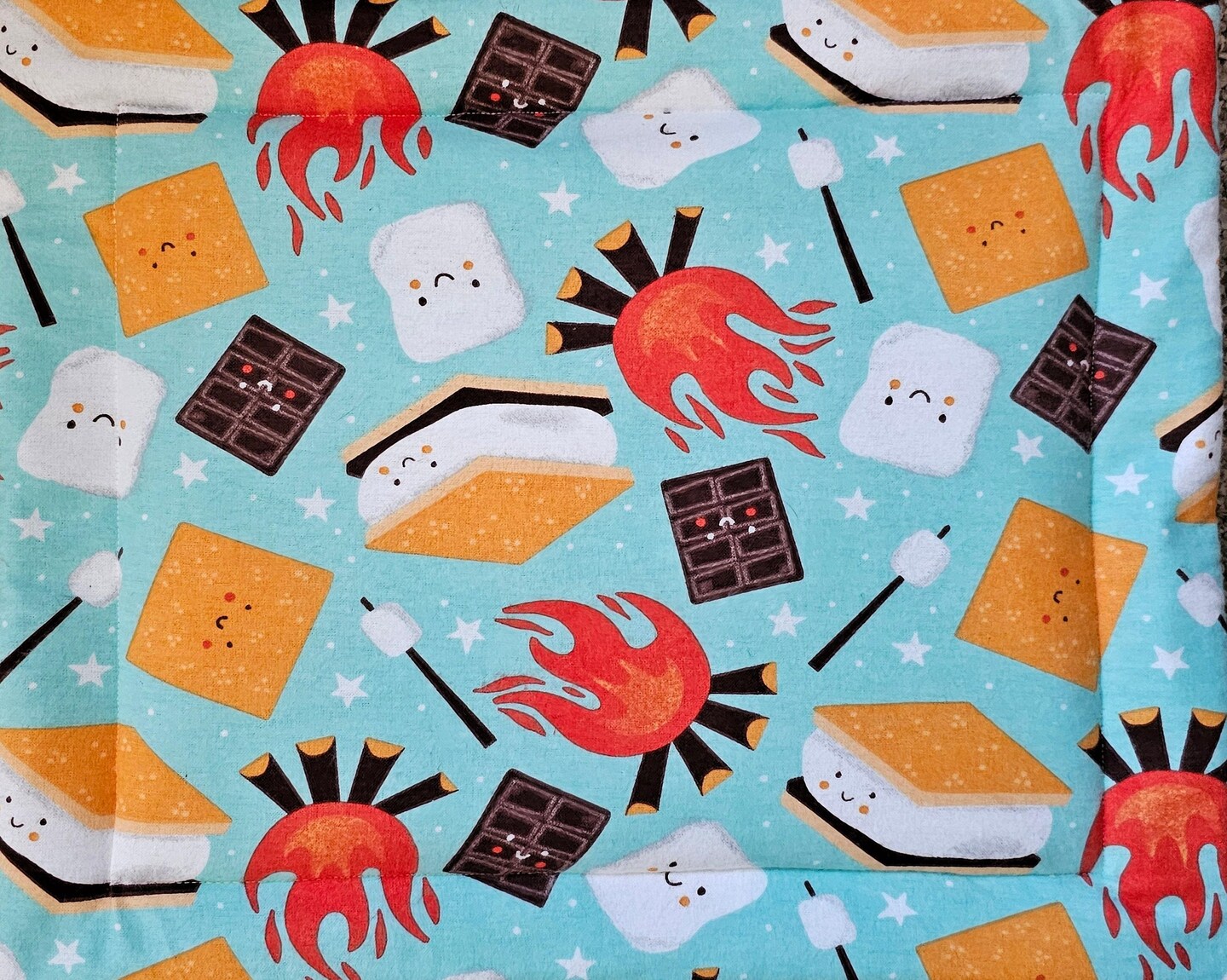 product name is Self Warming Cat Bed with Happy Smores, Washable Flannel Fabric, Cozy Winter Cat Blankets with Self Heating Material, Cold Weather Cat Bed