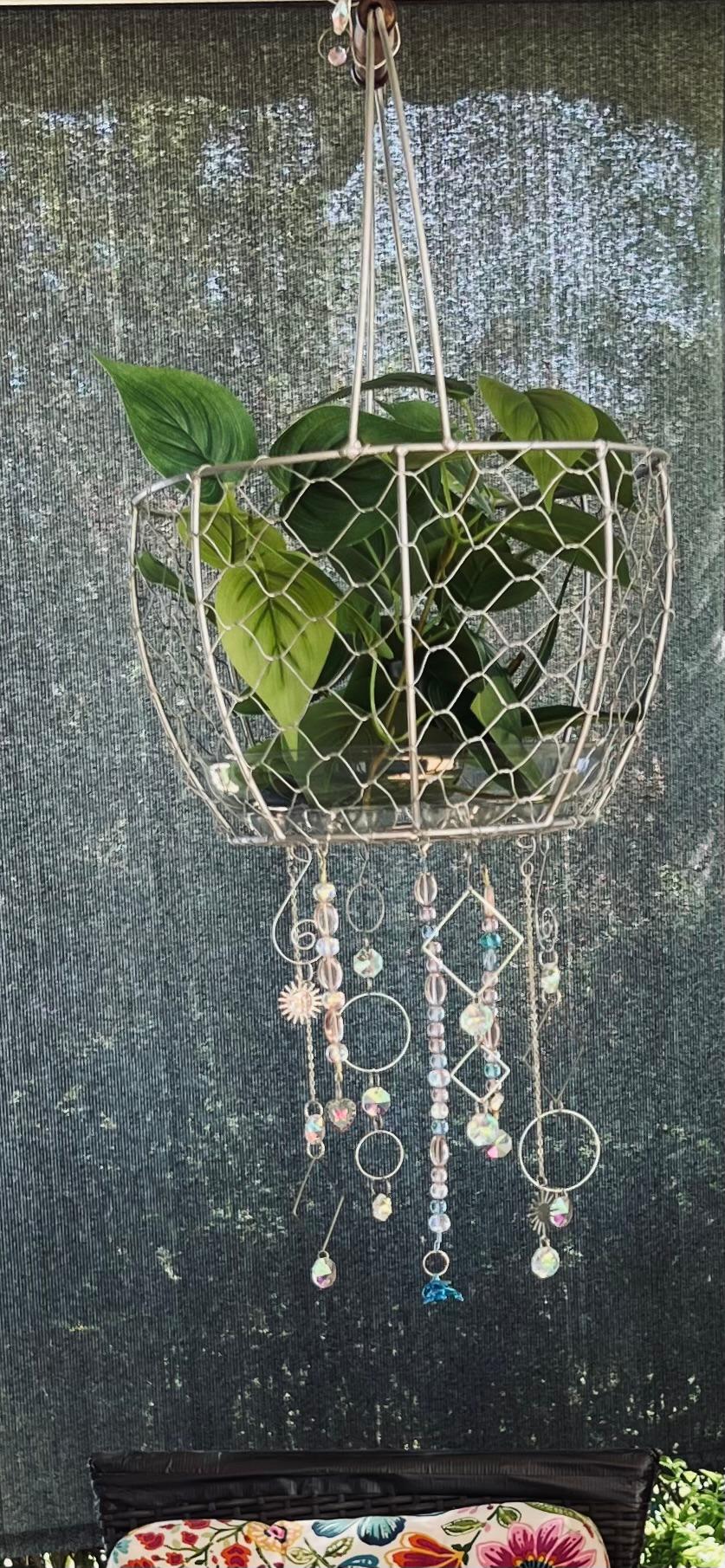 Silver wire hanging basket with iridescent glass bead and wire shaped  suncatchers hanging from bottom- 24" long - 11" round basket plants |  MakerPlace by Michaels