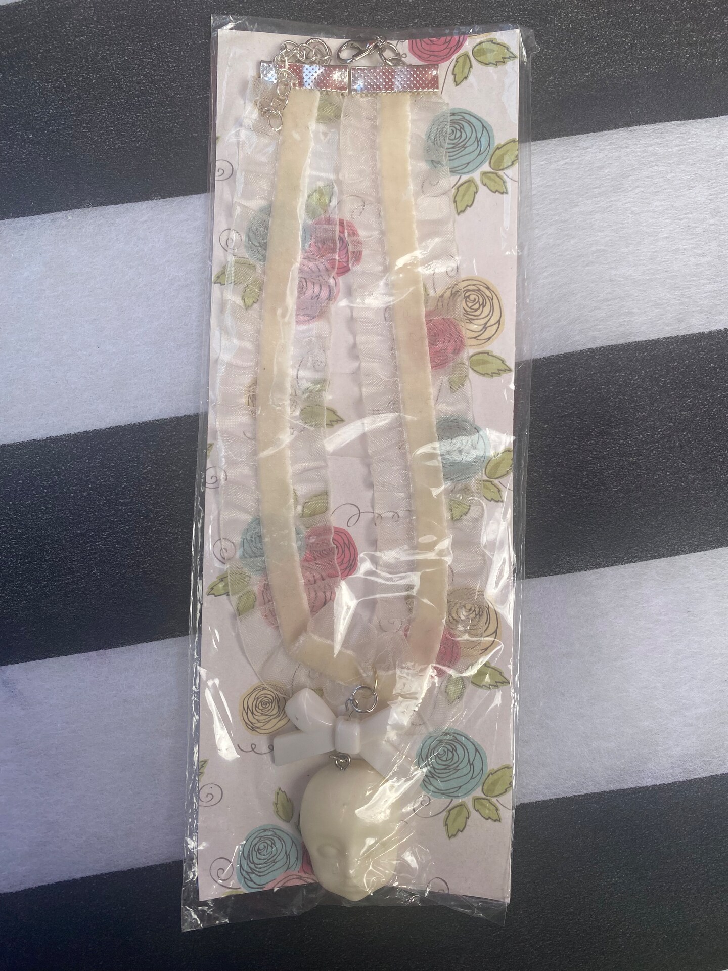product name is Almond Milk Doll Head Choker