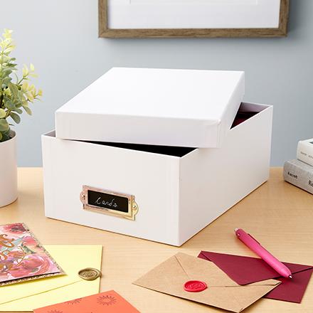 white photo box on table surrounded by envelopes