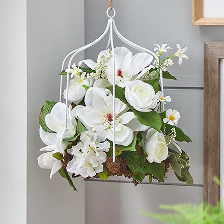faux white flowers and greenery in hanging cage