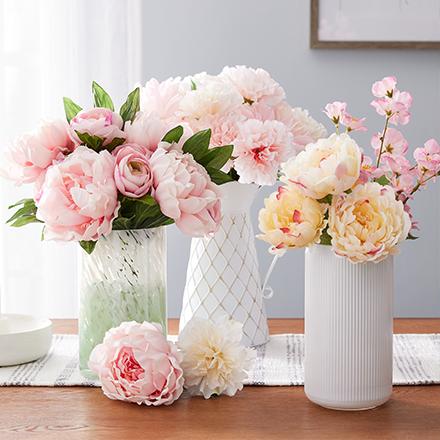 pink faux bushes in three white vases