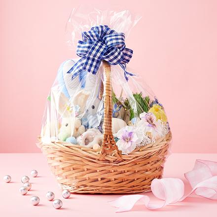 Easter basket wrapped in cellophane on pink background