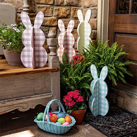 wood bunny cutouts with Easter basket and plants on porch