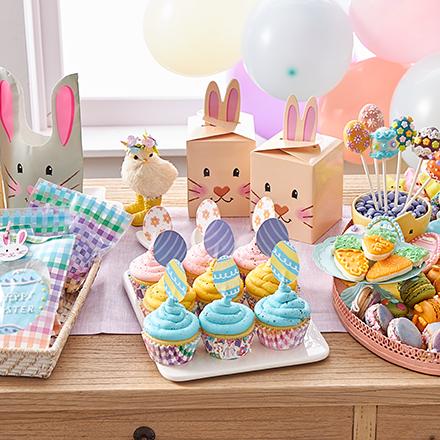 Easter cupcakes and bunny treats on wood table with balloons