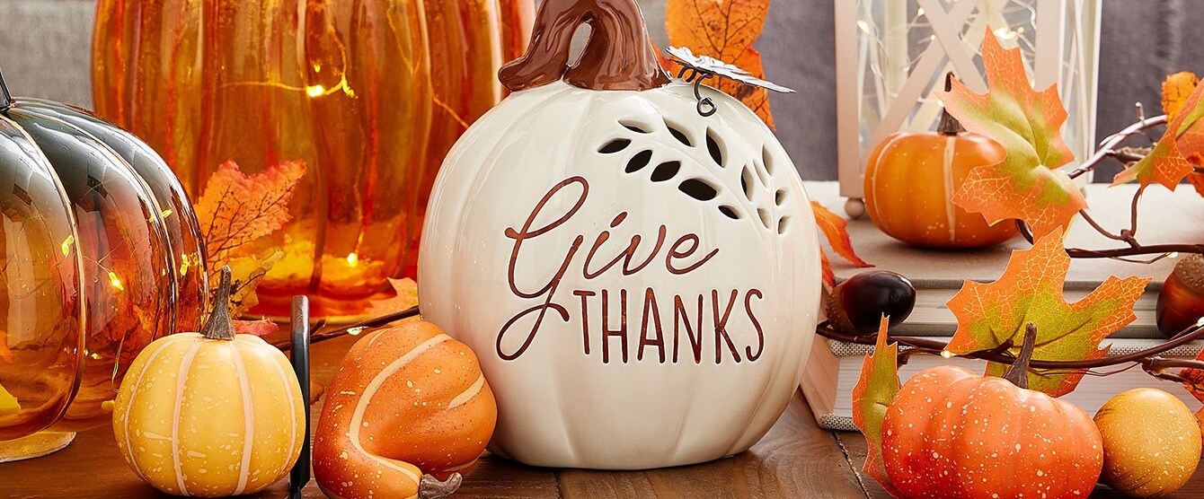 glass and plastic pumpkins on tables with fall faux floral