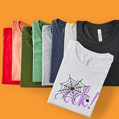 Folded tshirts on a orange background. the featured shirt is white with a spiderweb on it and the word "eek"