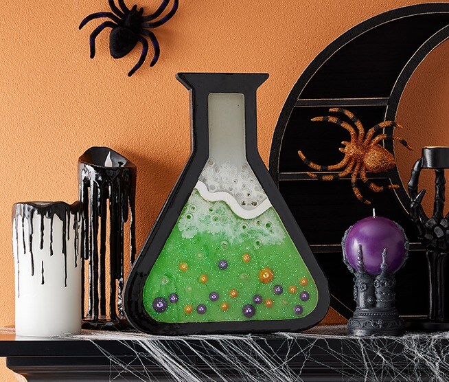 Halloween chemistry beaker creative on a black mantel