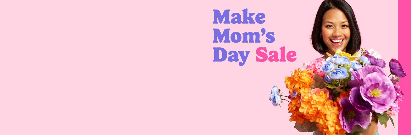woman holding bouquet of orange, purple and blue flowers with Make Mom's Day Sale logo on pink background