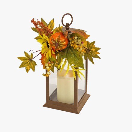 Lantern with some Fall leaves in orange and green