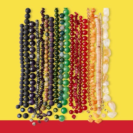 brown, purple, blue and green beads lined up in assorted shapes