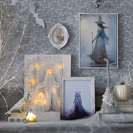 Haunted Forest Collection: Halloween decorations in white colors: a white crow, a white canvas, a white lighted tabletop tree, a broom and a pumpkin.