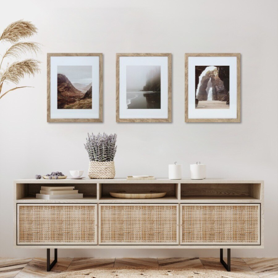 Three rustic wood matted frames above a console