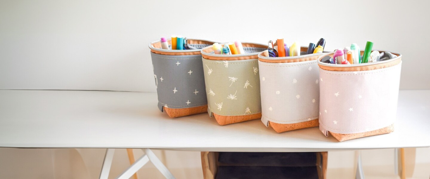 four fabric pencil bags with art supplies