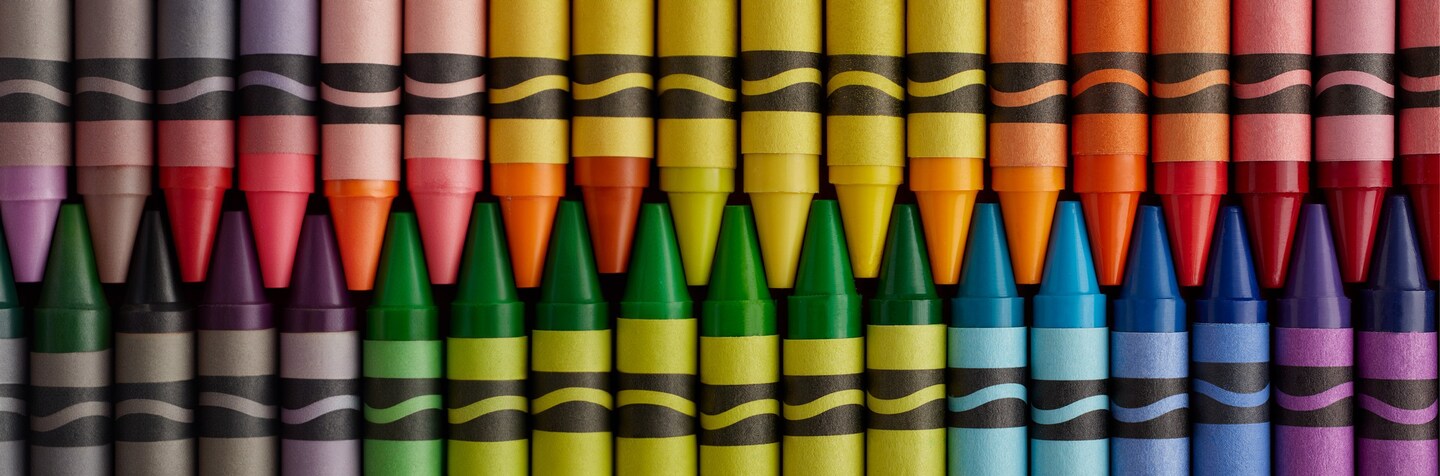Various brightly colored crayons arranged tip to tip