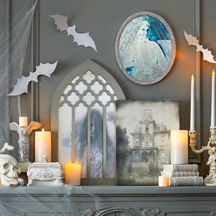 Haunted Forest Collection: Halloween decorations in white colors: a white crow, a white canvas, a white lighted tabletop tree, a broom and a pumpkin.