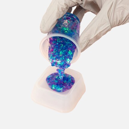 hand pouring blue glitter resin