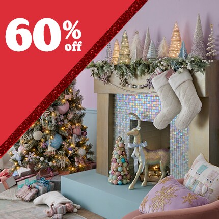 purple room with reindeer and stockings on mantel, with decorated Christmas tree with 60% off in white text in red triangle