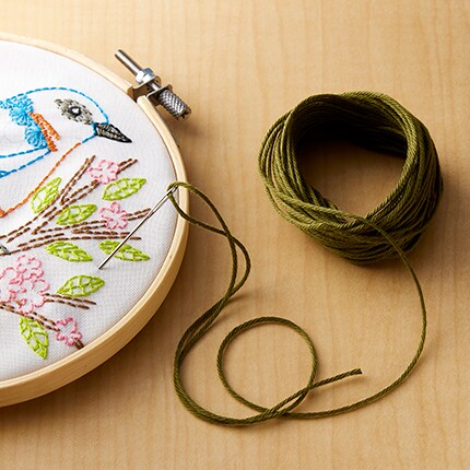 spools of thread in assorted colors upright on table