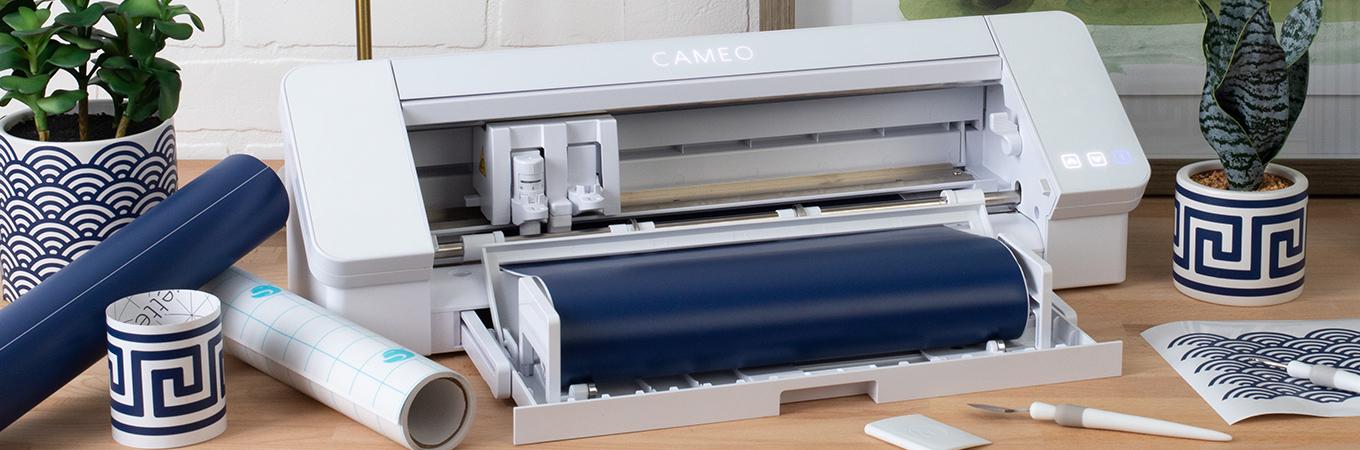 Silhouette machine, vinyl, and craft tools on table