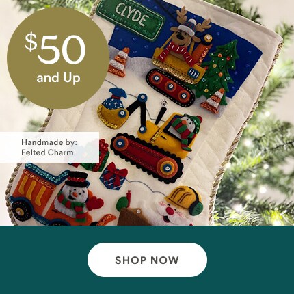MakerPlace by Michaels Festive stocking decorated with colorful felt vehicles, snowman, and Christmas tree. Text reads "$50 and Up, Handmade by: Felted Charm". Shop Now button below.