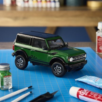 green model bronco suv on blue craft mat with assorted testor paint and accessories