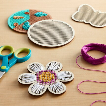 wood cross stich flower project with wood butterfly and circle canvases, scissors and purple thread