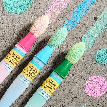 Sidewalk chalk pens against concrete