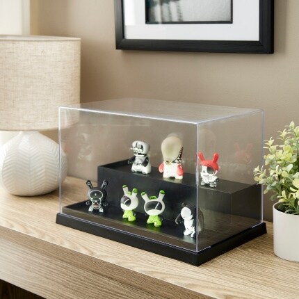 display case with collectible figures on table next to lamp