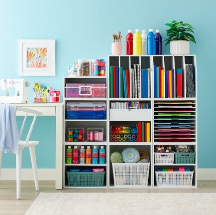 modular storage cubes and shelves with craft supplies next to desk