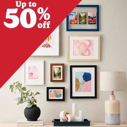 two brown wood and one white wood frames with white mats with 50% off in white text over red triangle