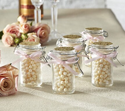 clear favor jars with ivory candies and pink ribbon