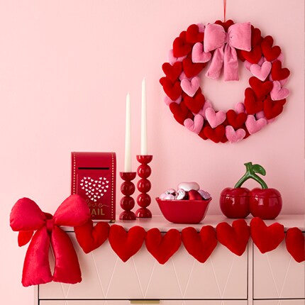red heart and bow decor on mantel with wreath above
