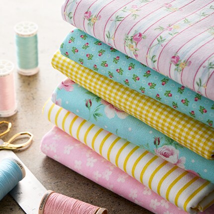 pink pastels apparel fabric on table with measuring tape and scissors 