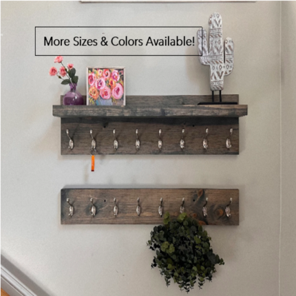 MakerPlace by Michaels Wooden wall shelf with hooks is decorated with pink flowers, a cactus ornament, and a small plant. Text reads, "More Sizes & Colors Available!"