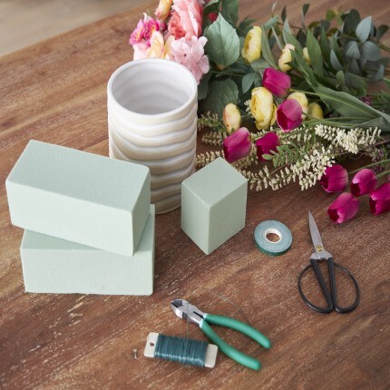 imitation flowers a flower potting supplies sitting on table  