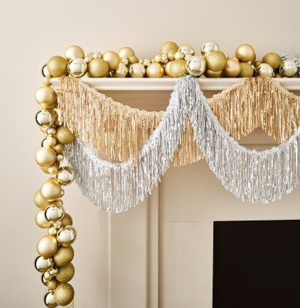 silver and gold garlands on tan mantel