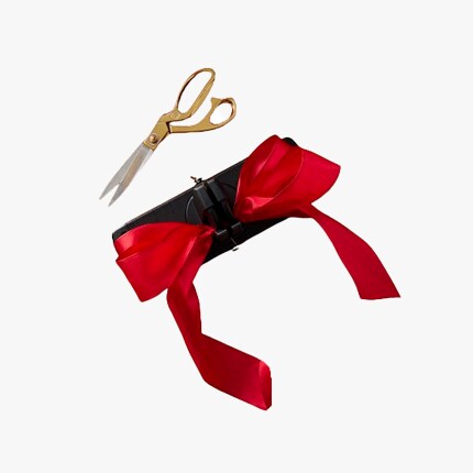 bow maker with red ribbon and scissoers