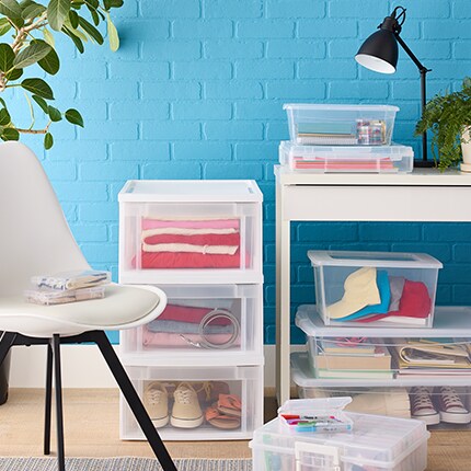chair next to desk and plastic storage boxes and drawers