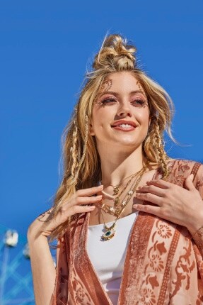 woman with layered jewelry of necklaces with different charms 