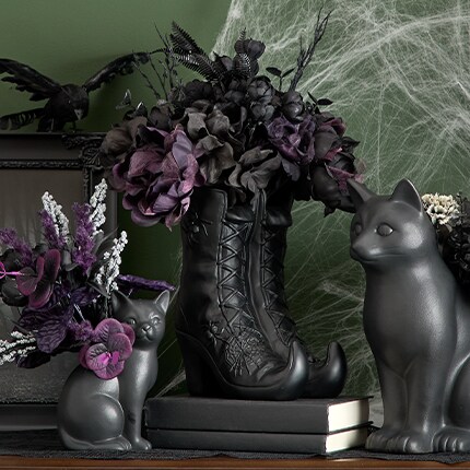 Black and red bushes in a black pot over a coffee table.