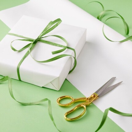 gift wrap paper and present with green ribbon and scissors