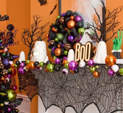 mantle with spider web covering, Halloween wreath and assorted Halloween accents