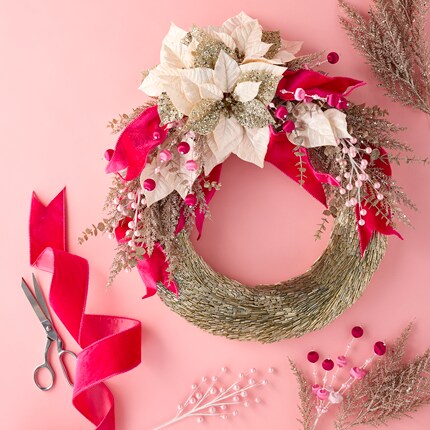 A wreath with flowers and pink ribbon