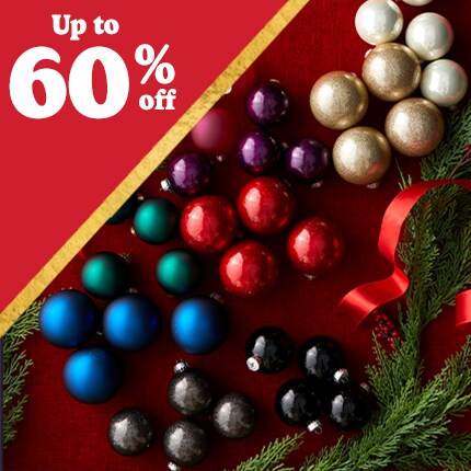 decorative ornaments laid out in fake snow with 50% off in white text over red triangle