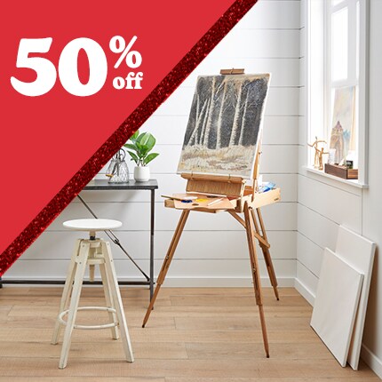 easel with painted canvas in studio with 50% off in white text in red triangle