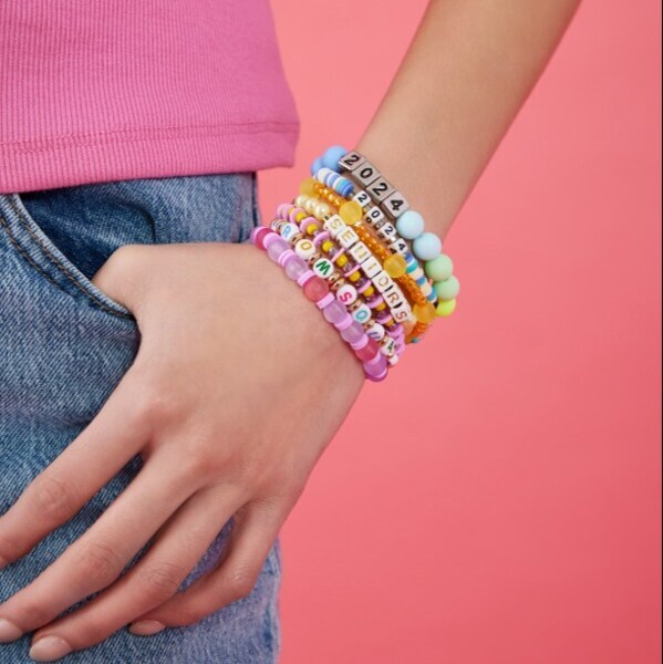 A woman's hand hanging from her pocket with bracelets on her wrist.